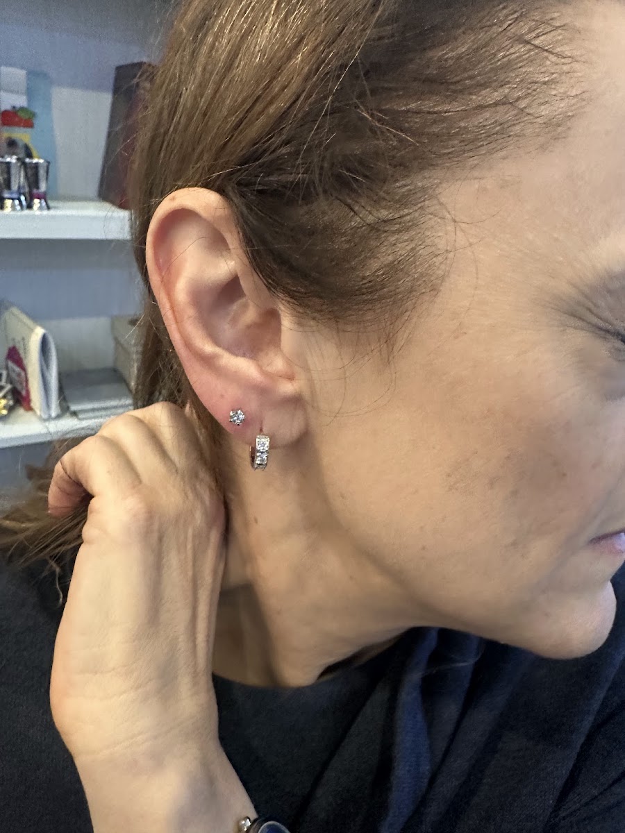 Side view of an ear with a stud and small earring